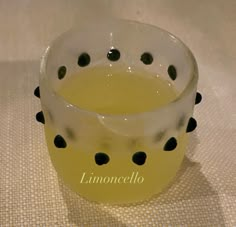 a glass filled with liquid sitting on top of a table next to a white cloth