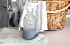 a bottle of soap sitting on top of a counter next to a basket and towel