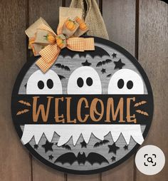 a welcome sign with bats and pumpkins hanging on a door hanger that says, welcome