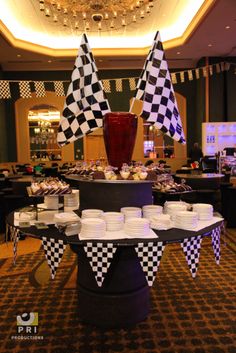 a buffet table set up with checkered flags and desserts on the tables in front of them