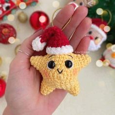 a hand holding a tiny crocheted star ornament with a santa hat on it