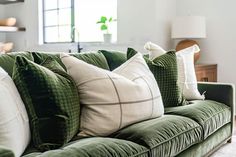 a green couch with several pillows on it