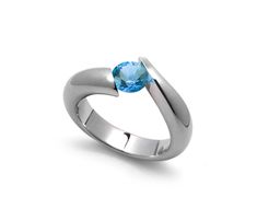 a ring with a blue topazte stone in the center and two silver bands around it