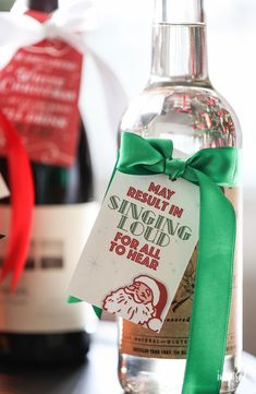 a bottle of gin sitting on top of a table with a green ribbon around it