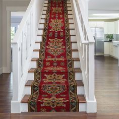 a red carpeted staircase leading to an open floor plan