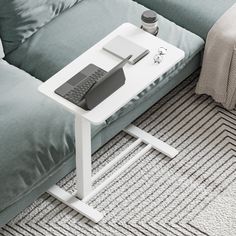 a small table with a remote control on it next to a couch in a living room