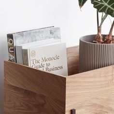 there is a book in the holder on the shelf next to a potted plant