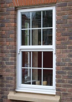 a white window sitting on the side of a brick building