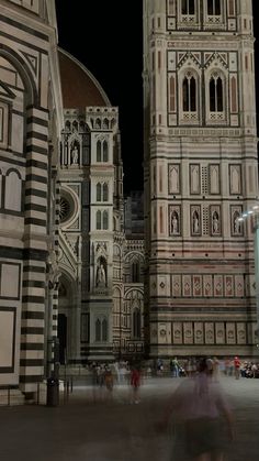 people are walking around in front of an ornate building