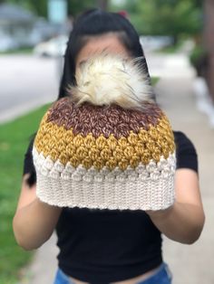 a woman wearing a knitted hat with a fur pom