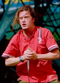 a man in red shirt holding a microphone