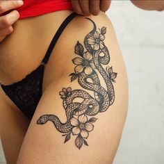 a woman's thigh with a snake and flowers tattoo on her side ribcage