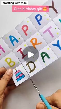 someone cutting out the letters for a birthday card