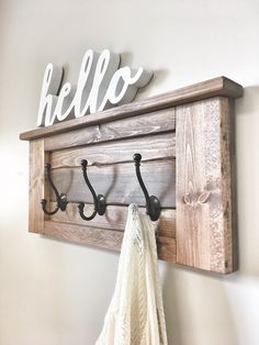 a coat rack with hooks and a towel hanging from it's hooks on the wall