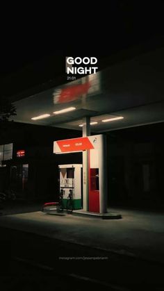 an empty gas station at night with the sign good night on it's side