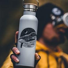 a person holding a water bottle with a whale on it