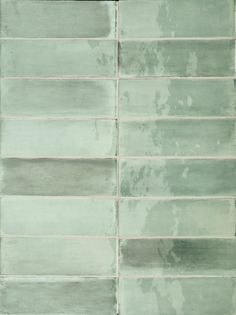 a green tile wall with white grouting on it