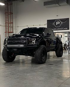 a large black truck parked inside of a building