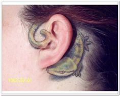 an ear with a lizard tattoo on it