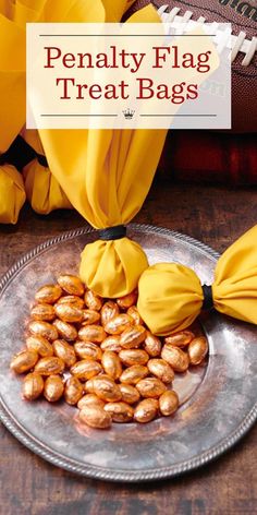 a plate topped with peanuts next to yellow flowers and a football on the table behind it