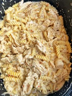 a bowl filled with pasta covered in chicken and cheese sauce on top of a table