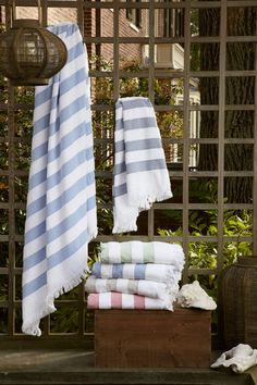 several towels stacked on top of each other in front of an iron fence and window