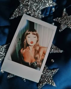 a polaroid photo of a woman with long hair and red lips on a blue background