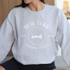 This sweatshirt is perfect for all the Pilates girls or the Pilates girly in your life! Unisex sizing for this Gildan 1800 sweatshirt that is perfect to wear going to and from workout classes, to the gym, or even around the house! As always, please reach out with any questions! * 50% cotton, 50% polyester * Pre-shrunk * Classic fit * 1x1 athletic rib knit collar with spandex * Air-jet spun yarn with a soft feel * Double-needle stitched collar, shoulders, armholes, cuffs, and hem This product is made especially for you as soon as you place an order, which is why it takes us a bit longer to deliver it to you. Making products on demand instead of in bulk helps reduce overproduction, so thank you for making thoughtful purchasing decisions! Crew Neck Sweater With Logo For Loungewear, Logo Print Crew Neck Sweater For Loungewear, Sporty Crew Neck Sweatshirt With Cozy Fit, Sporty Cozy Fit Crew Neck Sweatshirt, Sporty Crew T-shirt For Loungewear, Sporty Crew Neck T-shirt For Loungewear, Sporty Crew Neck Sweater For Workout, Crew Neck Cotton Activewear For Leisure, Cotton Sweatshirt For Gym With Relaxed Fit