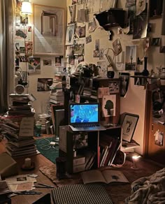 a cluttered room with a laptop on the desk