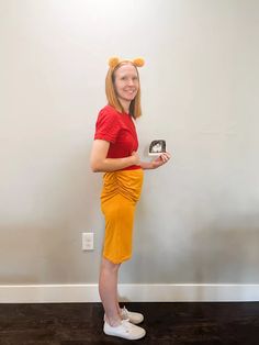 a woman dressed as winnie the pooh is holding a small box with an image on it