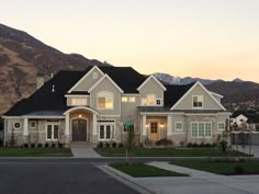 a large white house with mountains in the background