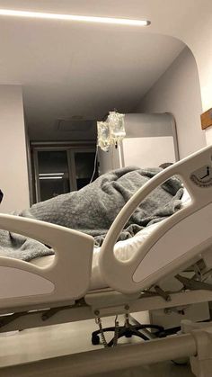 an empty hospital bed in a room with lights on