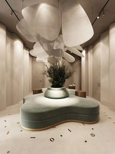 a large flower pot sitting on top of a round table in a room with white walls