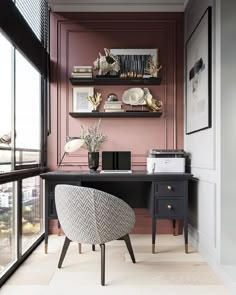 a home office with pink walls and black desk in front of a window overlooking the city