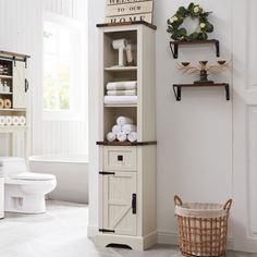 a bathroom with a white toilet and wooden cabinet