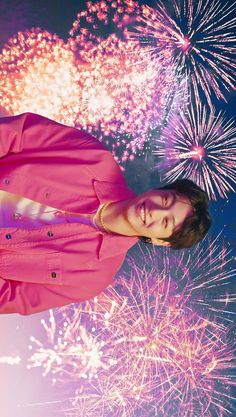 a woman standing in front of colorful fireworks