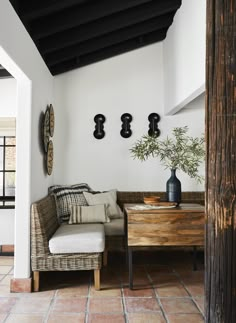 a living room with a couch, table and two vases on the wall next to it