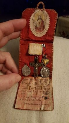 a hand holding an old fashioned cross and medal