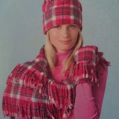 a woman wearing a red and white plaid scarf with a pink hat on her head