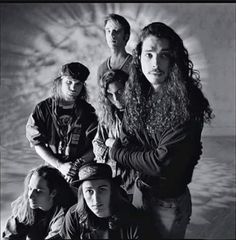 a group of people standing next to each other in front of a white background with black and white photo