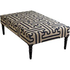 a black and white ottoman sitting on top of a wooden leg rest with an intricate design