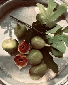 some figs and leaves on a metal tray