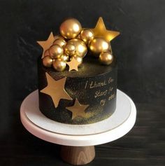 a black and gold cake with stars on top