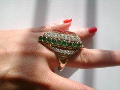 "This is a Stunning 925 Sterling Silver and Bronze Gold Plated Metal With Gemstone Pear Shape Cut Ruby Red and Surrounded by Round Cut Emerald Green and Sparkling Cubic Zirconia Accents Very Fancy Statement Cocktail Ring Beautiful Design Size 9. Imitation Simulated Stone or Possibly Real Stone Green Emerald, Red Ruby and Diamond Like? (I'm not sure what the materials of this ring is) Nonetheless this ring is beautiful and it looks like the real thing!! The ring band is stamped/marked 925. The ri Green Jeweled Round Ring, Elegant Green Emerald Ring With Stones, Elegant Green Rings For Festive Occasions, Festive Green Ring Jewelry, Festive Green Jewelry Ring, Festive Green Ring, Real Stone, Emerald Ring, Sparkle Diamonds