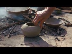 a person is making bowls out of clay