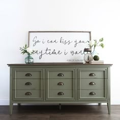 a green dresser with a sign above it