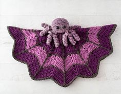 a crocheted purple and black object with an octopus on it