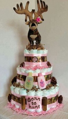 a three tiered cake decorated with deer antlers and baby items on it's sides