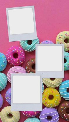 several different colored donuts with white frames in front of them on a pink background