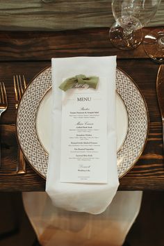 a table setting with place settings, silverware and napkins on it in front of the menu